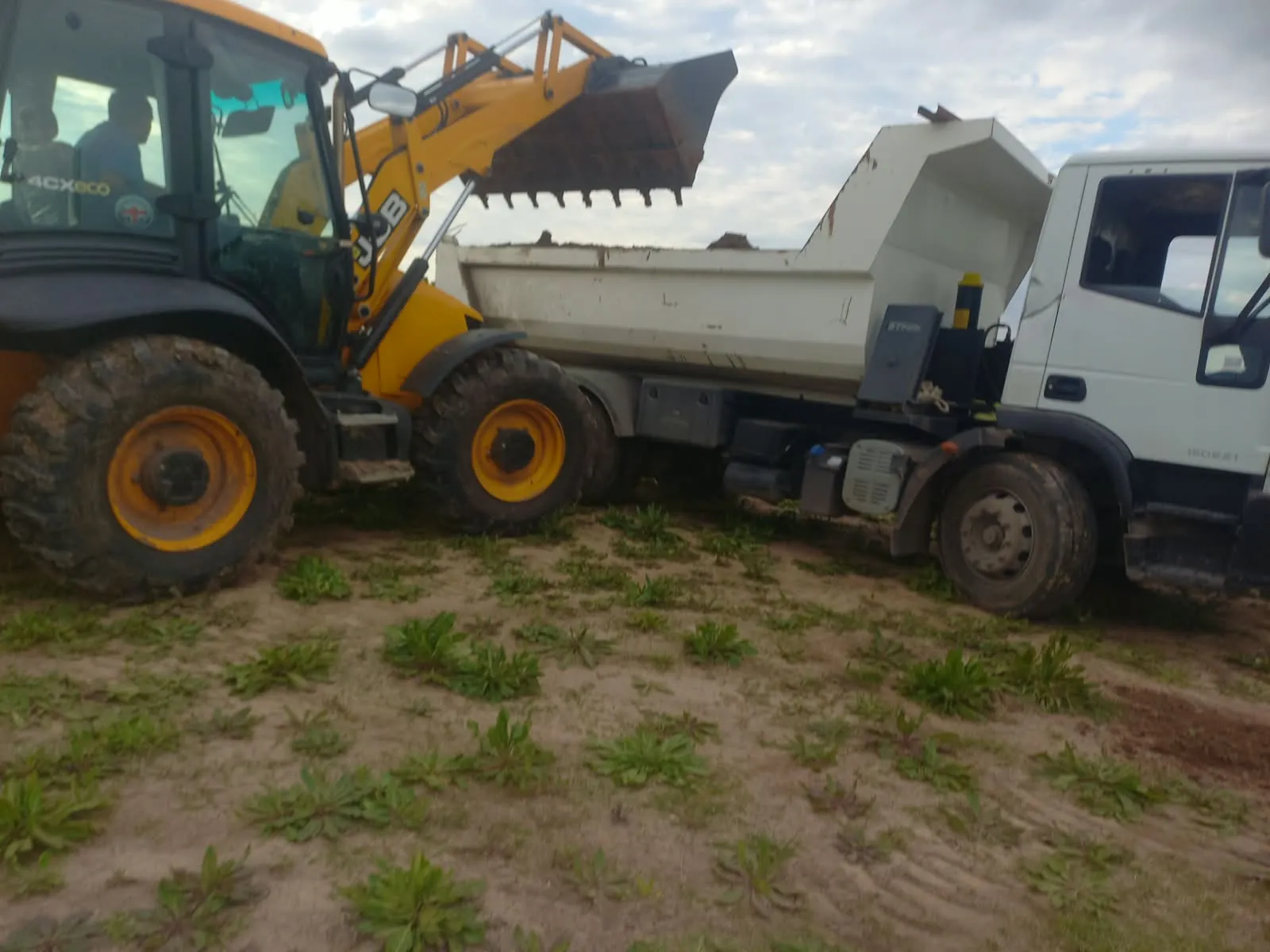 Maquinaria de movimiento de suelo junto a un camión